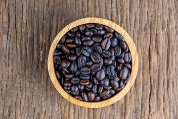coffee beans on wooden bowl isolated top viwe on old wood background.