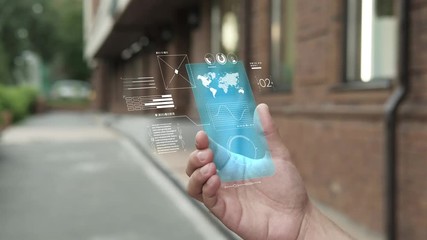 Handsome man using smartphone with futuristic screen. Businessman in the city use new transparent smart phone. World map. Multimedia technology. Future is now. Blue screen - Powered by Adobe