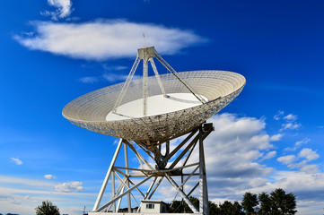 Array of satellite dishes or radio antennas against sky. Space o