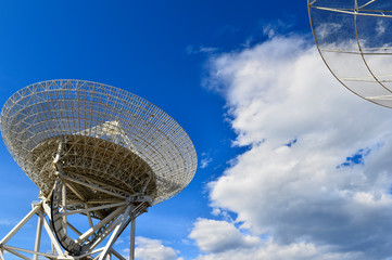 Array of satellite dishes or radio antennas against sky. Space o