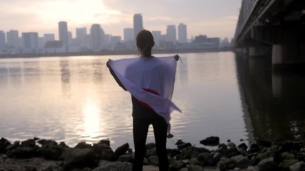 Smiling woman with Japanese flag proudly draped over her shoulders, HD, slow motion. - Powered by Adobe