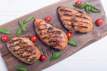 Grilled chicken breast ( fillet ) with basil and tomatoes