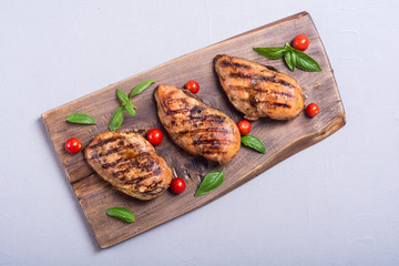 Grilled chicken breast ( fillet ) with basil and tomatoes