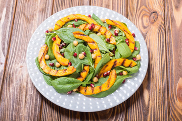 Autumn salad with pumpkin , spinach , pomegranate and chickpea