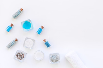Sea salt for spa and aroma spa cosmetics near towel and shells on white background top view space for text