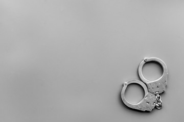 Metal handcuffs on grey background top view copy space
