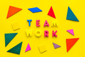 Teamwork concept. Teamwork techniques for students. Text teamwork lined with colored letters in abstract colored frame on yellow background top view