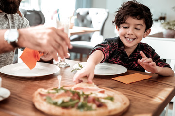Pizza with bacon. Smiling cute son holding piece of pizza with bacon spending weekend with father