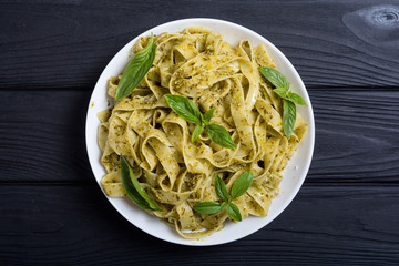 Pasta tagliatelle with green sauce pesto . Italian food background