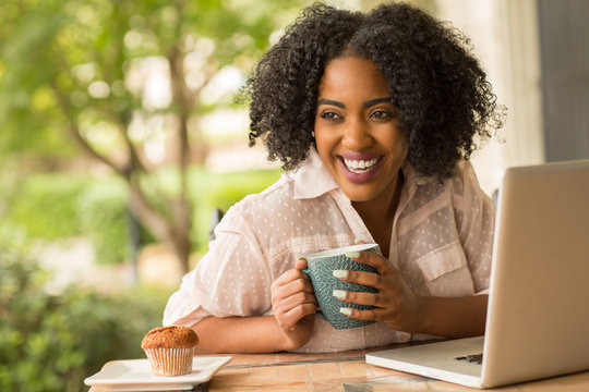 African American woman working and drinking coffee.