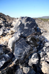 Large chunks of black obsidian glass exposed