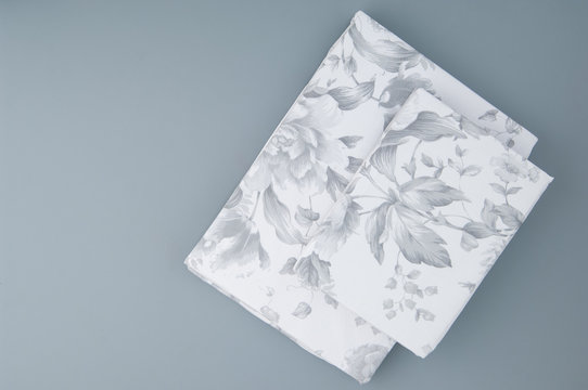 Folded New Bed Linen With Patterns On Grey Background, Top View