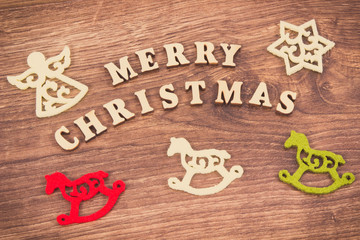 Inscription Merry Christmas with colorful decorations on rustic board. Vintage photo