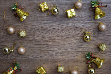 Golden bell, gift, ball on wooden table as background from top view.