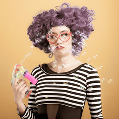Colorful fun portrait of woman playing with bubbles
