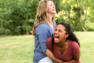 Mother and son laughing and playing at the park.