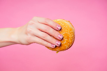 Woman blonde perfect skin eating burger. The beautiful girl is eating a hamburger appetizingly. A...