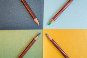 Colored pastel pencils are on colored paper.