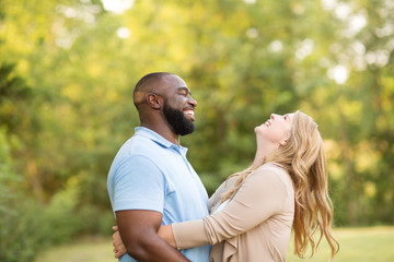 Loving mixed race couple hugging and laughing.