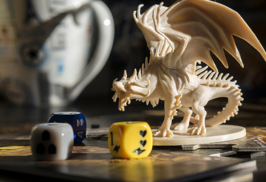 Playing  board game, role playing game, tabletop games. Figure of dragon, dices. Board games. Blurred background.