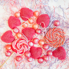Bright lollipops and marmalade on a light background. Photo in predominantly pink. The image is suitable for backgrounds and other design purposes.