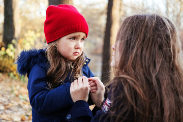 mother and daughter in park. scared child girl