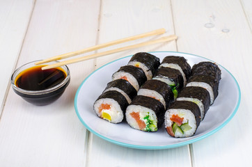 Rolls with salmon, plate on wooden table