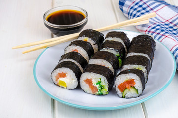Rolls with salmon, plate on wooden table