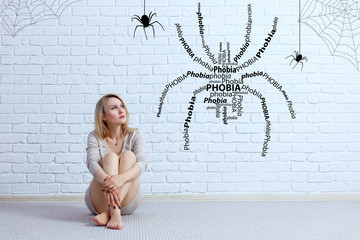 Young woman sitting on the floor and looking on imaginary spider.