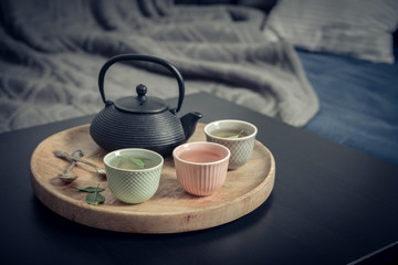 Black iron asian tea set on wooden tray