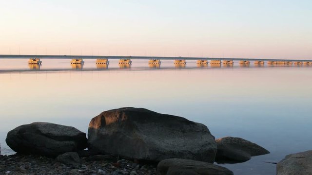 Low water bridge from Sedanka to the De Friz peninsula across the Amur Bay of Primorsky Krai Russia against the background of a red sunset sky. Far Eastern landscape. Soothing country scene.