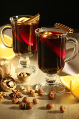 Two cups with ready mulled wine with anise, cinnamon and nuts around