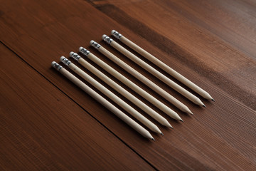 Wooden pencils on a brown background of natural wood