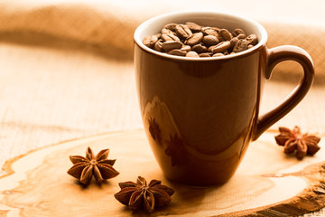 Brown coffee cup and coffee beans on wooden table