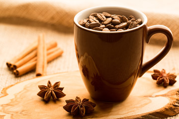 Brown coffee cup and coffee beans on wooden table
