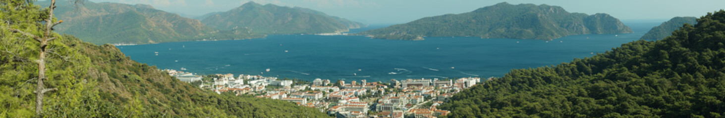 Fototapeta na wymiar Nature landscape with a city by the shore of the sea between the hills. mountain town panorama