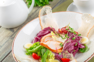 Fresh salad with chicken breast, arugula and tomato. Top view