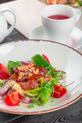 Closeup of a fresh green salad with sliced seared tenderloin steak