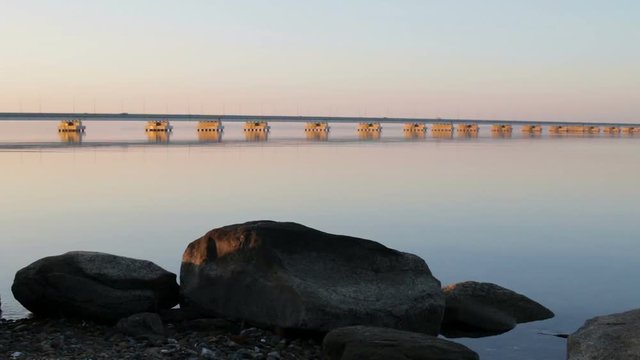 Low water bridge from Sedanka to the De Friz peninsula across the Amur Bay of Primorsky Krai Russia against the background of a red sunset sky. Far Eastern landscape. Soothing country scene.