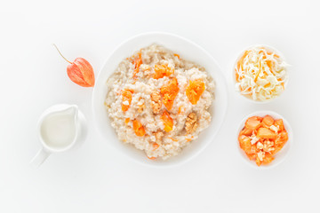 Oatmeal with pumpkin and nuts, salad, apple and jug of milk on a white background. View from above. Copy space. Close-up