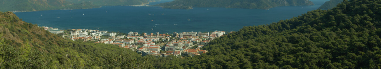 Fototapeta na wymiar Nature landscape with a city by the shore of the sea between the hills. mountain town panorama