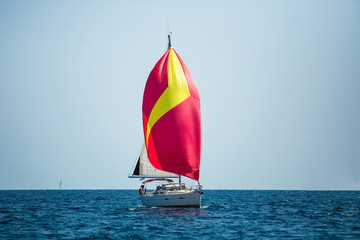 Luxury yacht with red sails at Regatta. Sailing in the wind through the waves at the Sea.