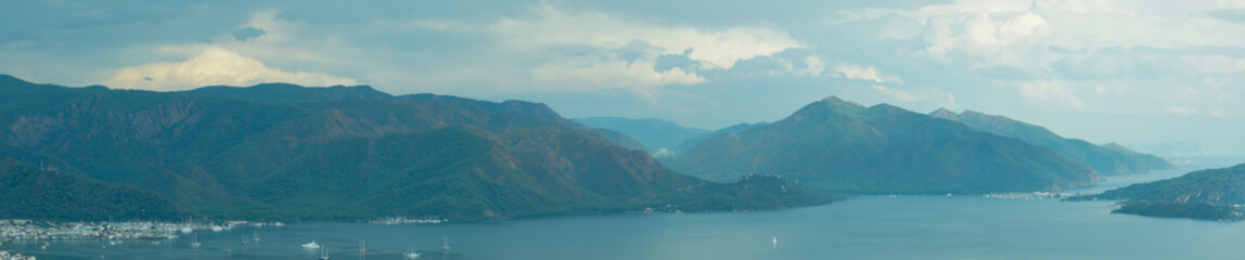 Obraz premium Nature landscape with a city by the shore of the sea between the hills. mountain town panorama