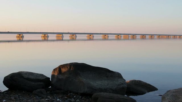 Low water bridge from Sedanka to the De Friz peninsula across the Amur Bay of Primorsky Krai Russia against the background of a red sunset sky. Far Eastern landscape. Soothing country scene.