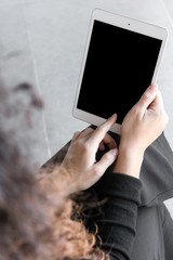 Beautiful woman with curly hair dressed on black working or shopping using computer or tablet