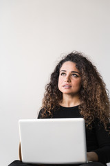 Beautiful woman with curly hair dressed on black working or shopping using computer or tablet