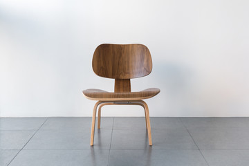 Modern and stylish brown and wood chair in empty room or office