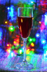 A glass of red wine on a bright colored illuminated background.