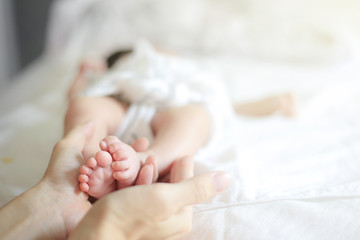 Tiny Newborn infant baby feets in mothers hands. concept for Happy Family Maternity parent concepts.