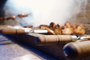 Деревянные ручки шампуров с готовым шашлыком и дымом позади!